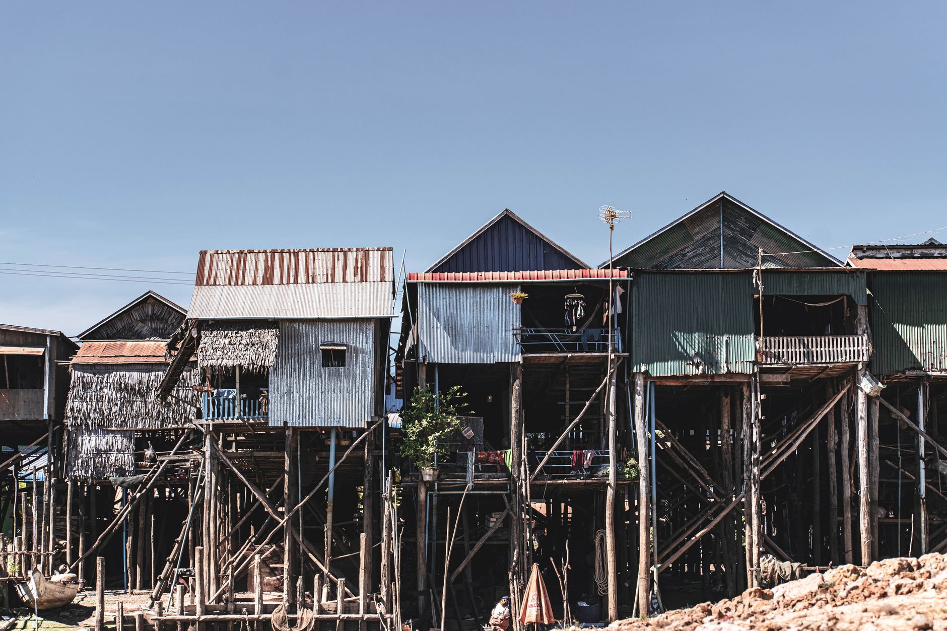 Traditional stilt houses built over water in a remote village setting at dusk