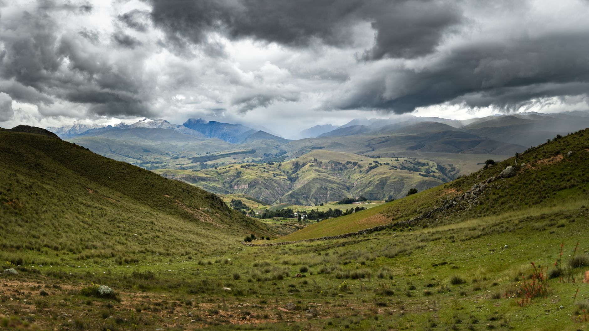 High-altitude Andean valley with volcanic peaks and open sky at dusk
