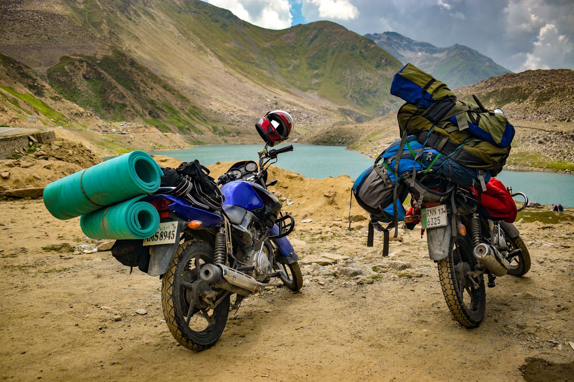 A motorbike rider navigating a steep mountain pass on a narrow road in northern Vietnam