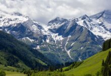 Wide alpine valley surrounded by snow-capped Tian Shan peaks in Kyrgyzstan