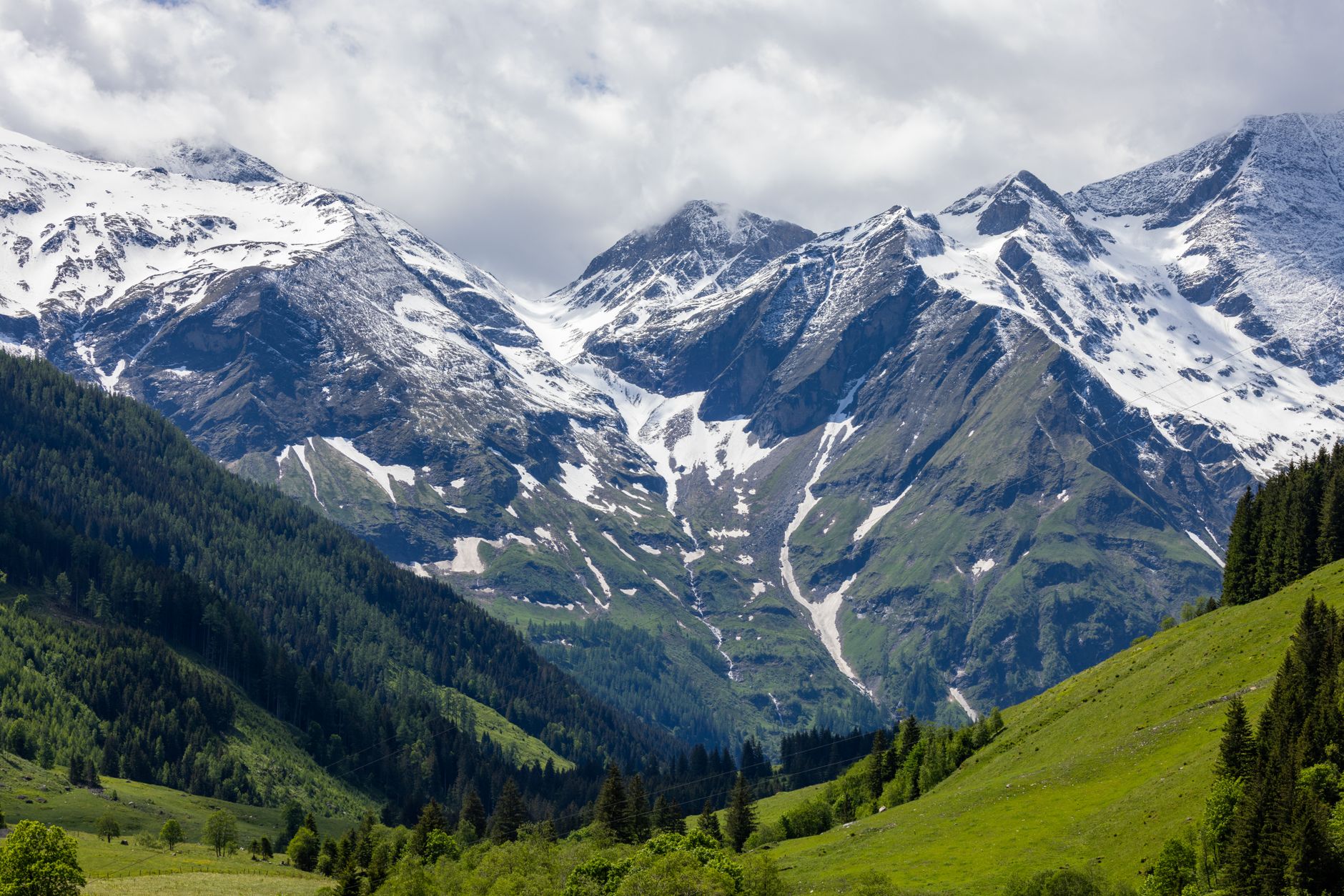 Wide alpine valley surrounded by snow-capped Tian Shan peaks in Kyrgyzstan