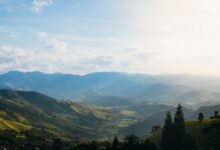 Wide view of a remote Ethiopian river valley with dry savanna and scattered trees