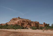Ancient earthen kasbah fortress rising above a palm grove in Morocco's Draa Valley