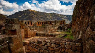 Ancient Inca stone terraces and ruins set against a mountainous jungle backdrop in Peru