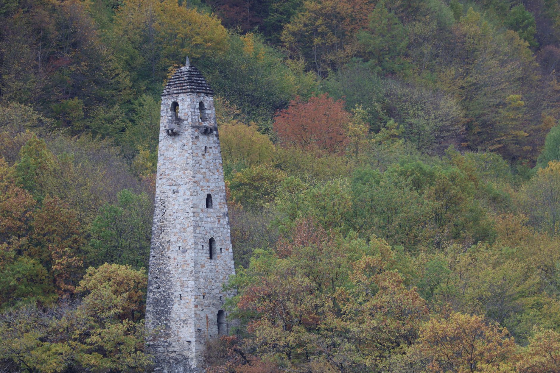 Medieval stone defensive tower rising against a mountain backdrop in Tusheti, Georgia