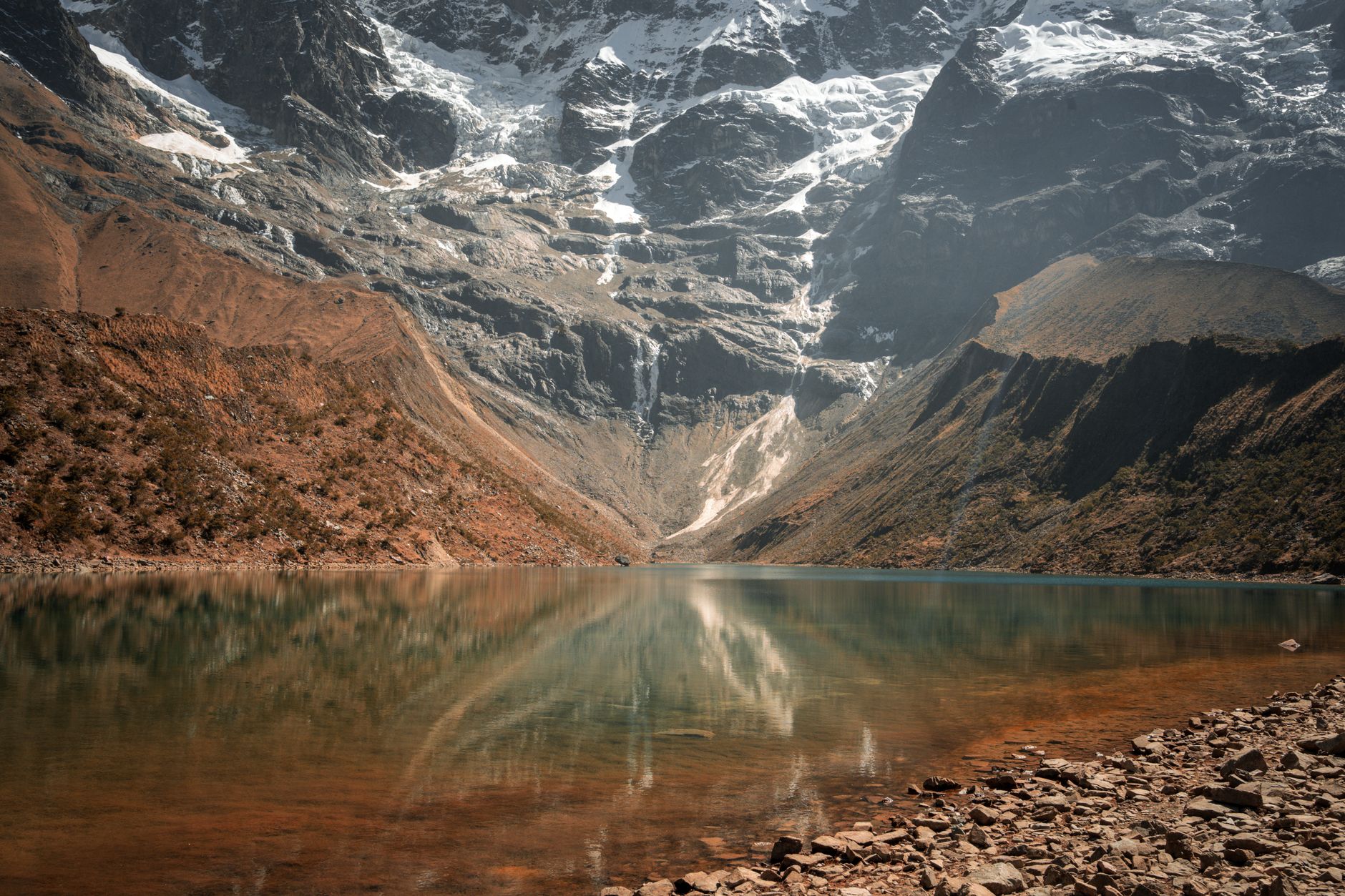 Vivid blue-green glacial lake at high altitude with rocky moraine surroundings