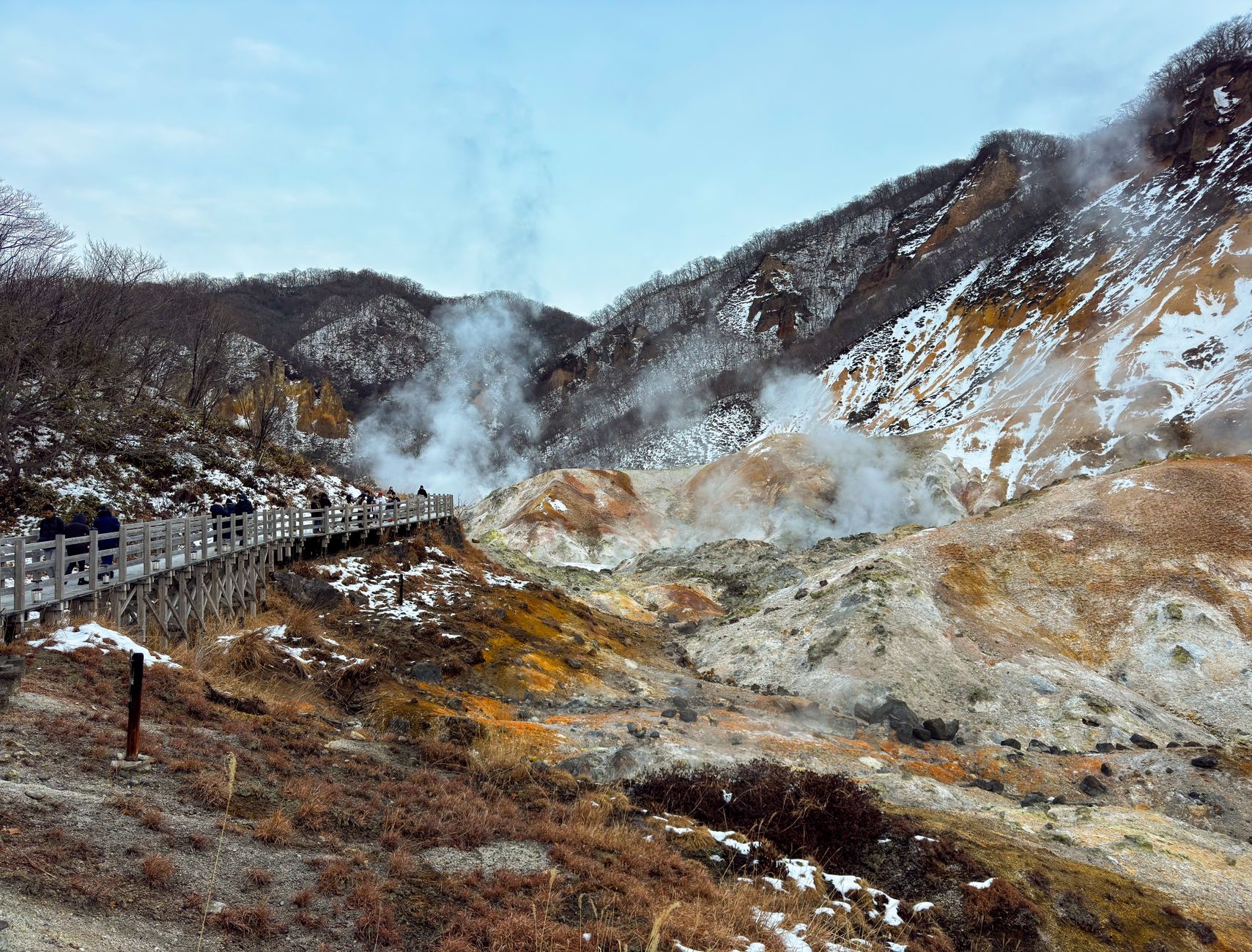 Steaming thermal pools surrounded by rocky high-altitude terrain