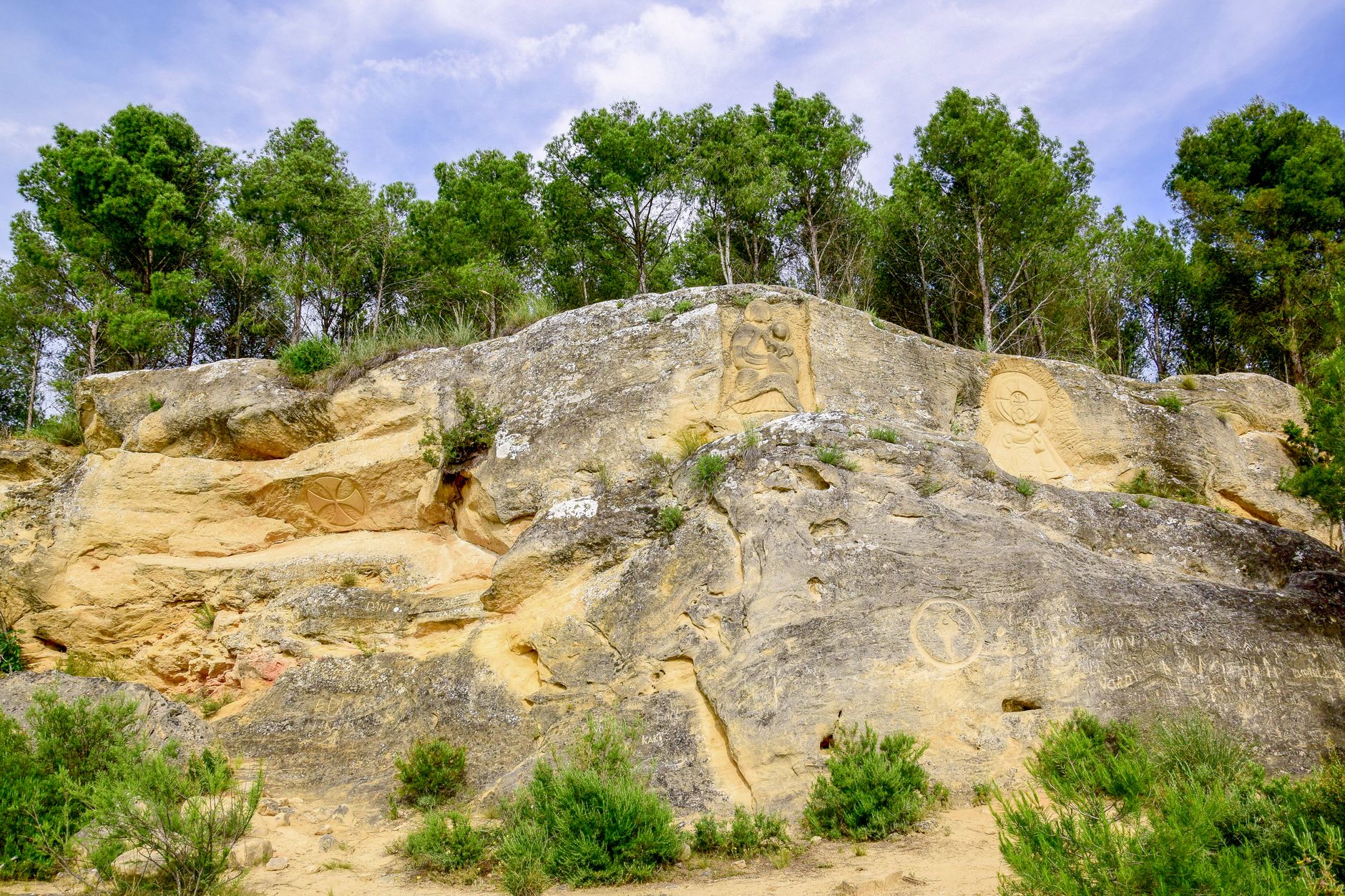 Prehistoric petroglyphs carved into sandstone rock in a desert environment