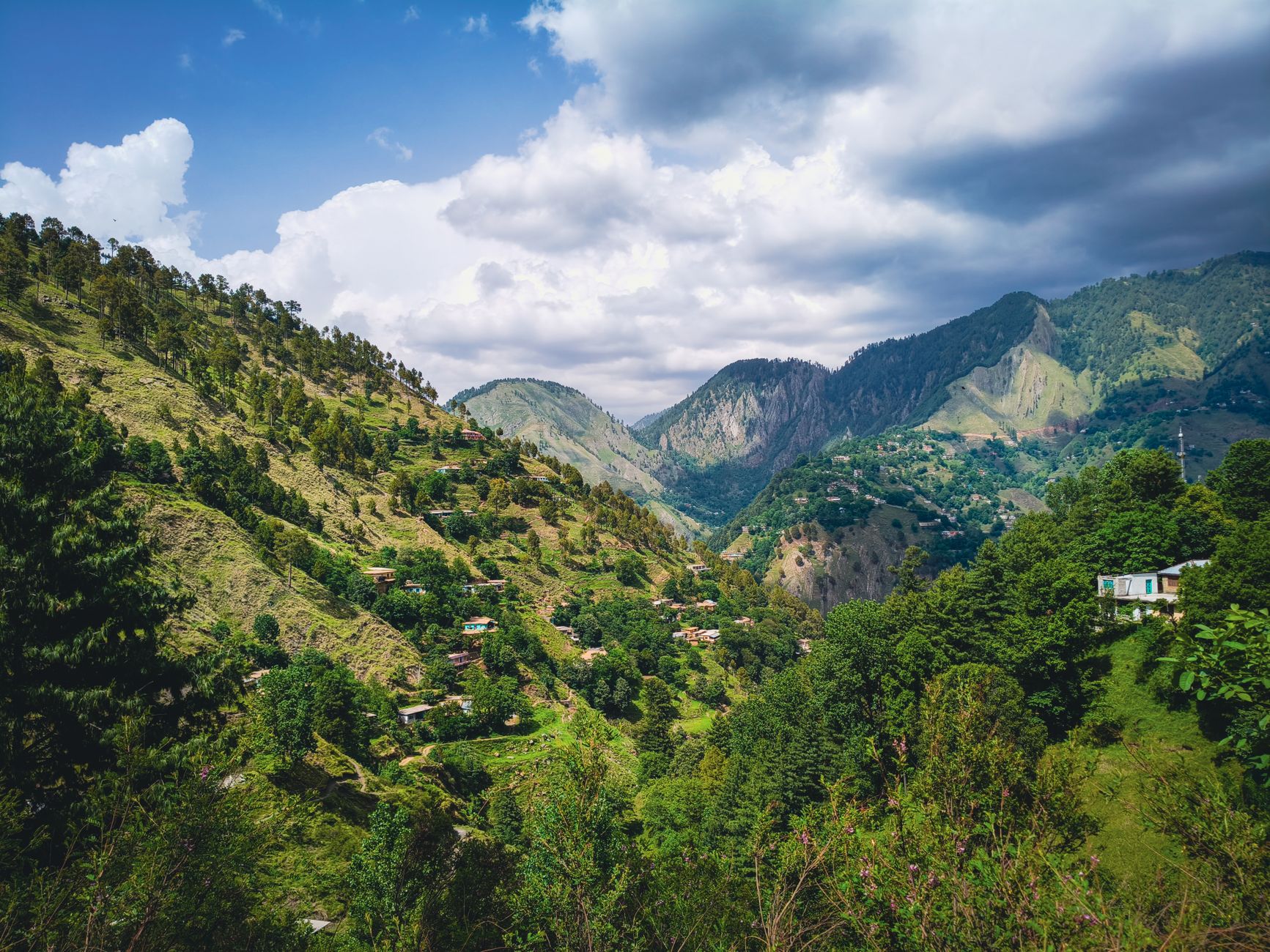 A remote village nestled in a steep mountain valley surrounded by forest