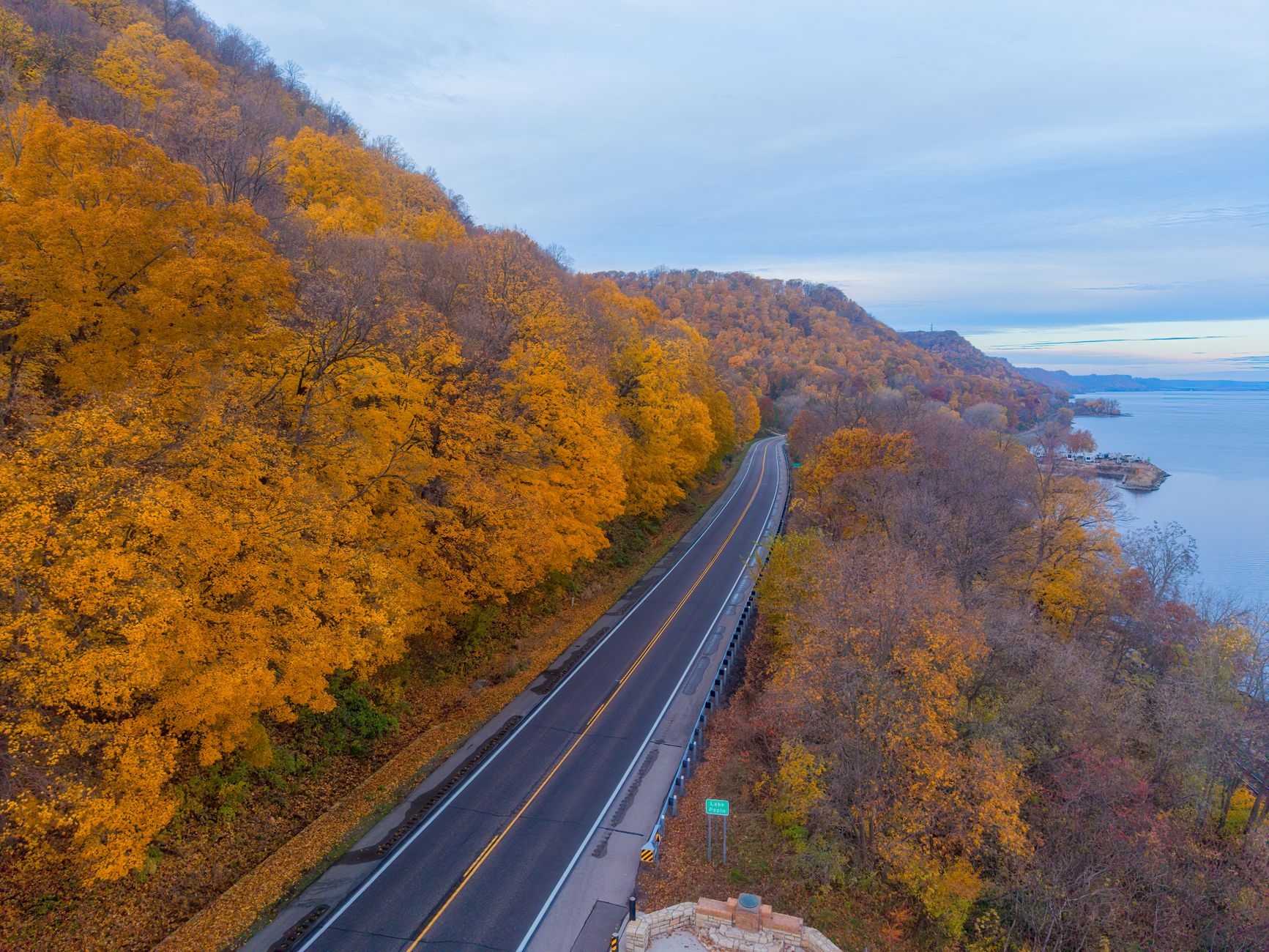 Yellow poplar trees lining a river path through a red rock canyon valley in autumn