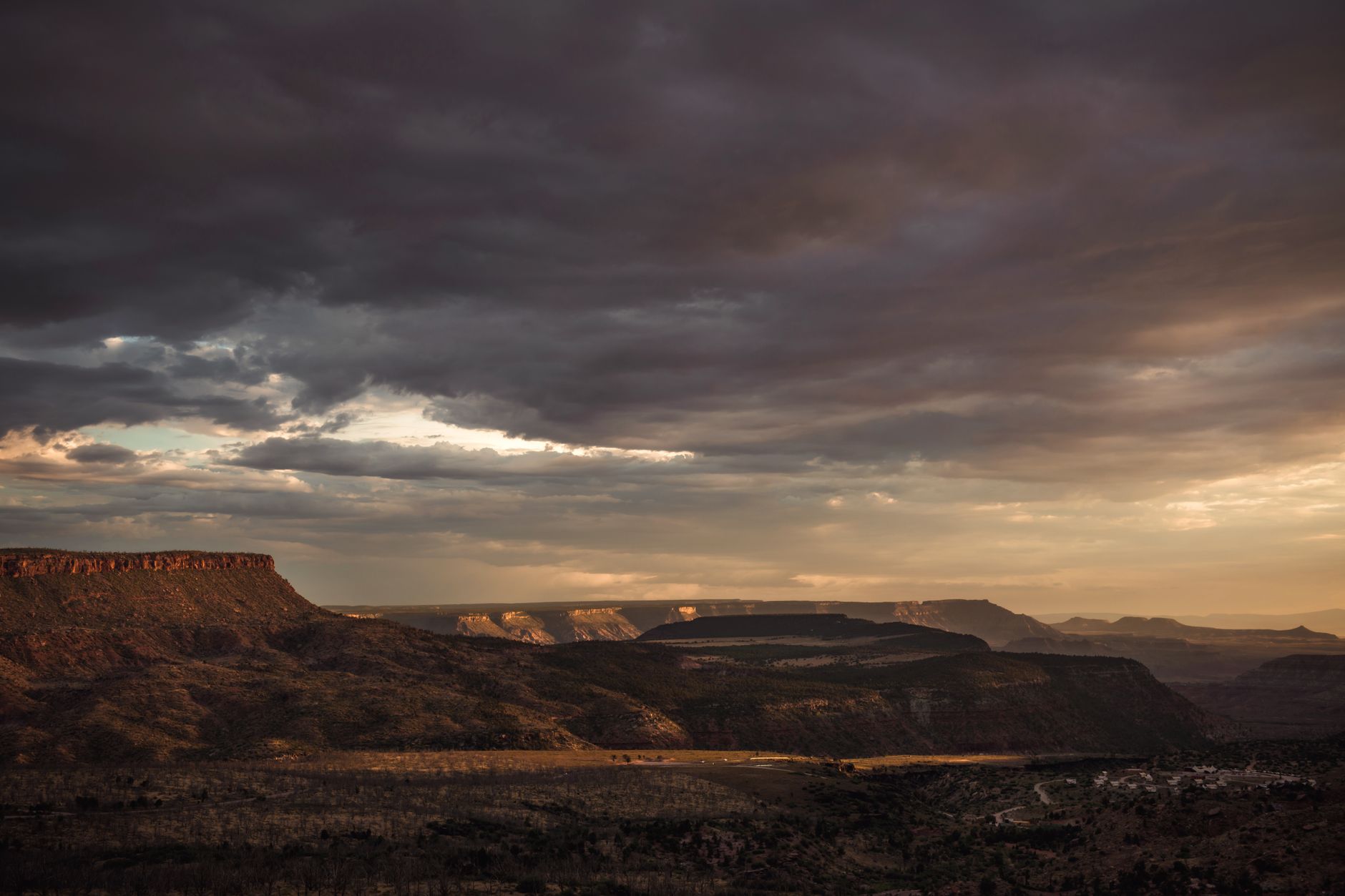 Narrow desert canyon bathed in warm orange sunset light