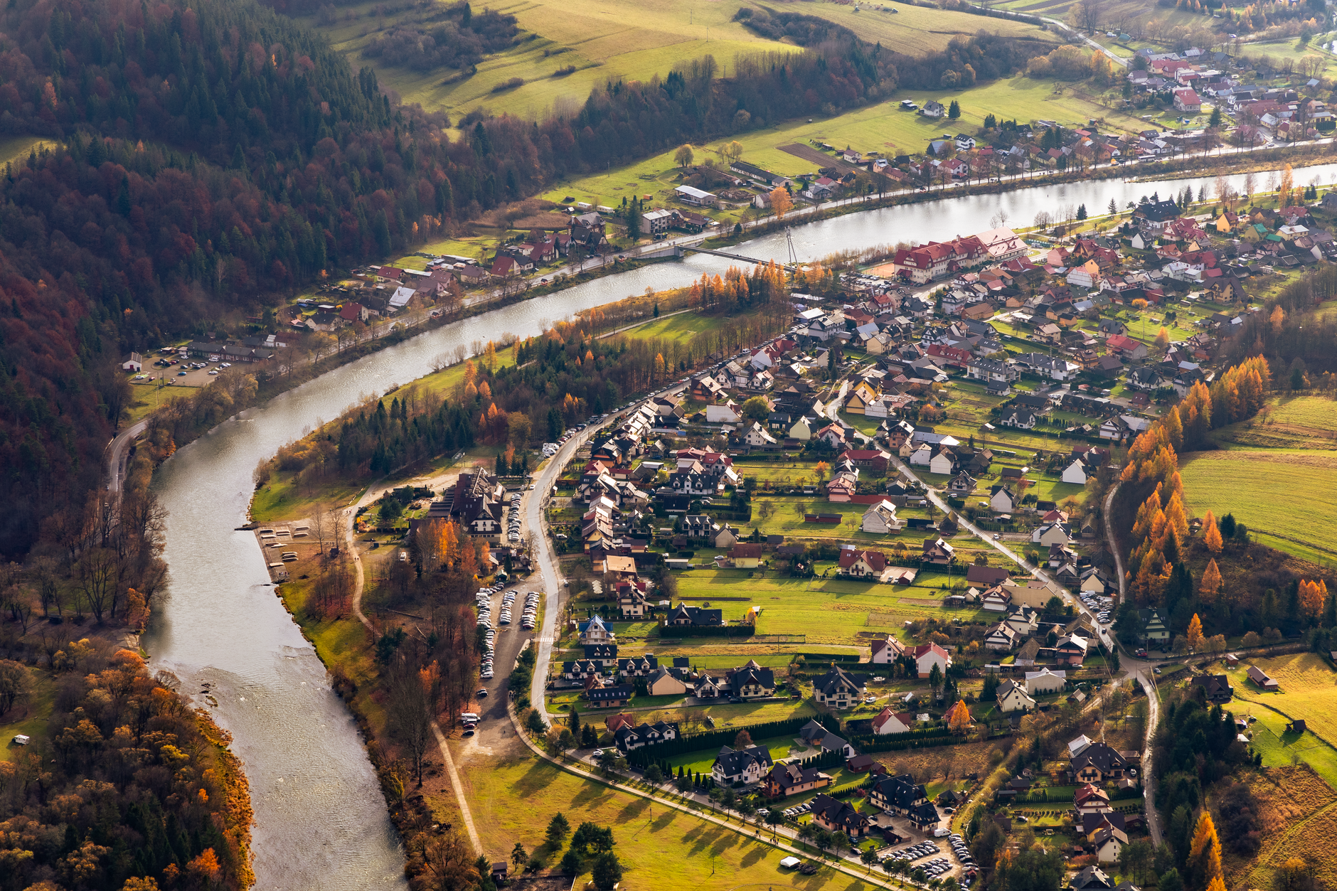 Small village nestled in an autumn mountain landscape with forested slopes
