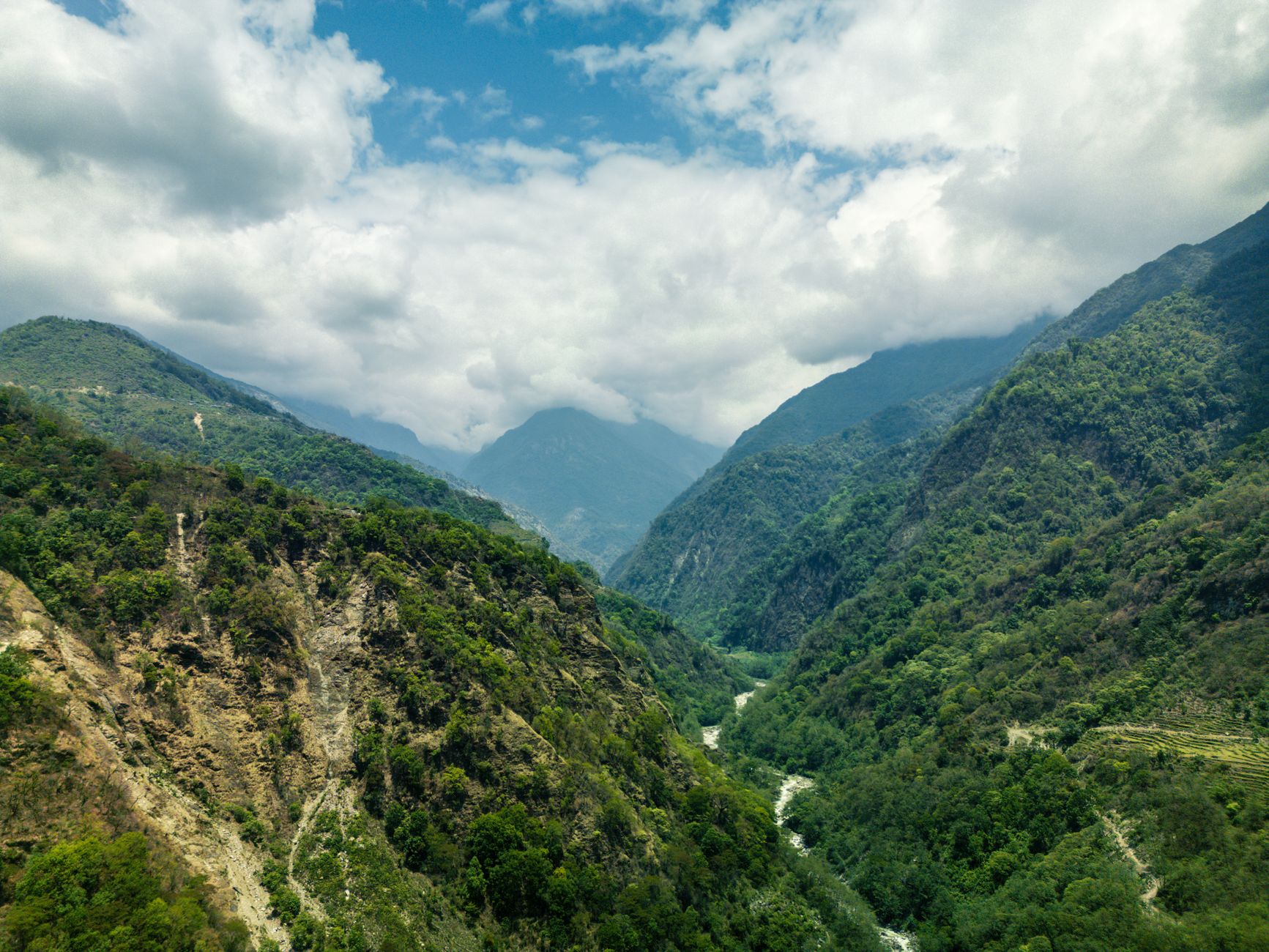 A remote Himalayan valley with terraced fields and snow-capped peaks in Nepal