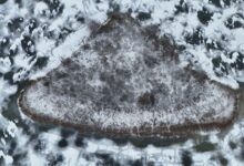 Aerial view of a small island surrounded by clear freshwater lake