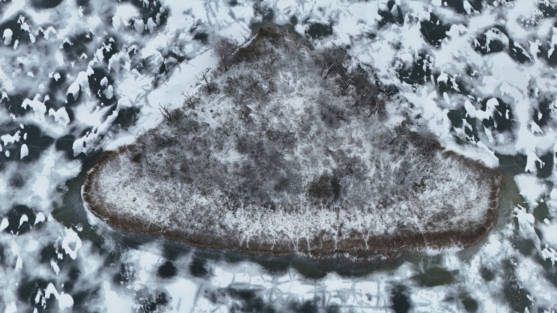 Aerial view of a small island surrounded by clear freshwater lake
