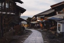 Cobblestone street winding through an ancient mountain village with stone buildings