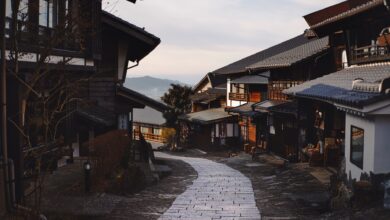 Cobblestone street winding through an ancient mountain village with stone buildings