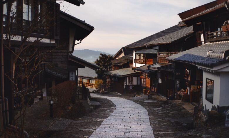 Cobblestone street winding through an ancient mountain village with stone buildings