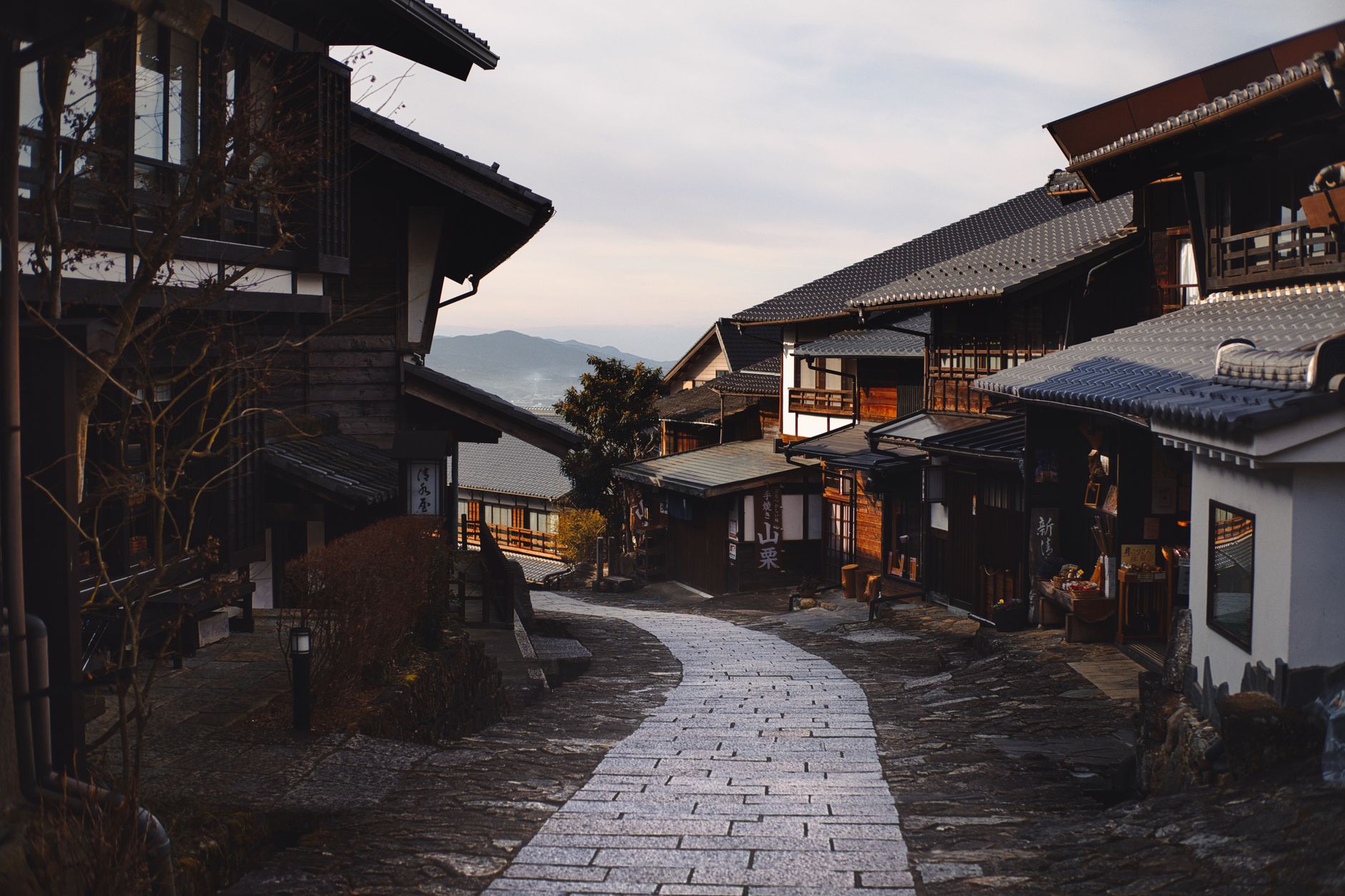 Cobblestone street winding through an ancient mountain village with stone buildings