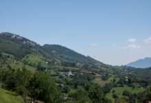 A small village nestled among dense forested mountain slopes in the Caucasus region