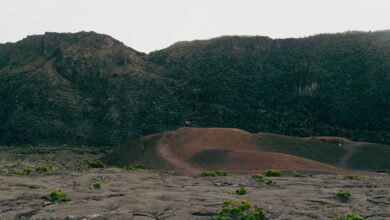 Barren volcanic landscape with steaming vents and cracked earth in an arid depression