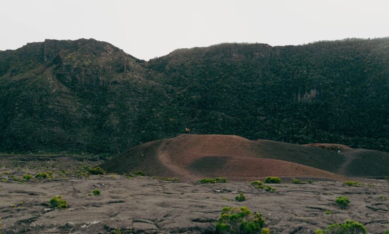 Barren volcanic landscape with steaming vents and cracked earth in an arid depression