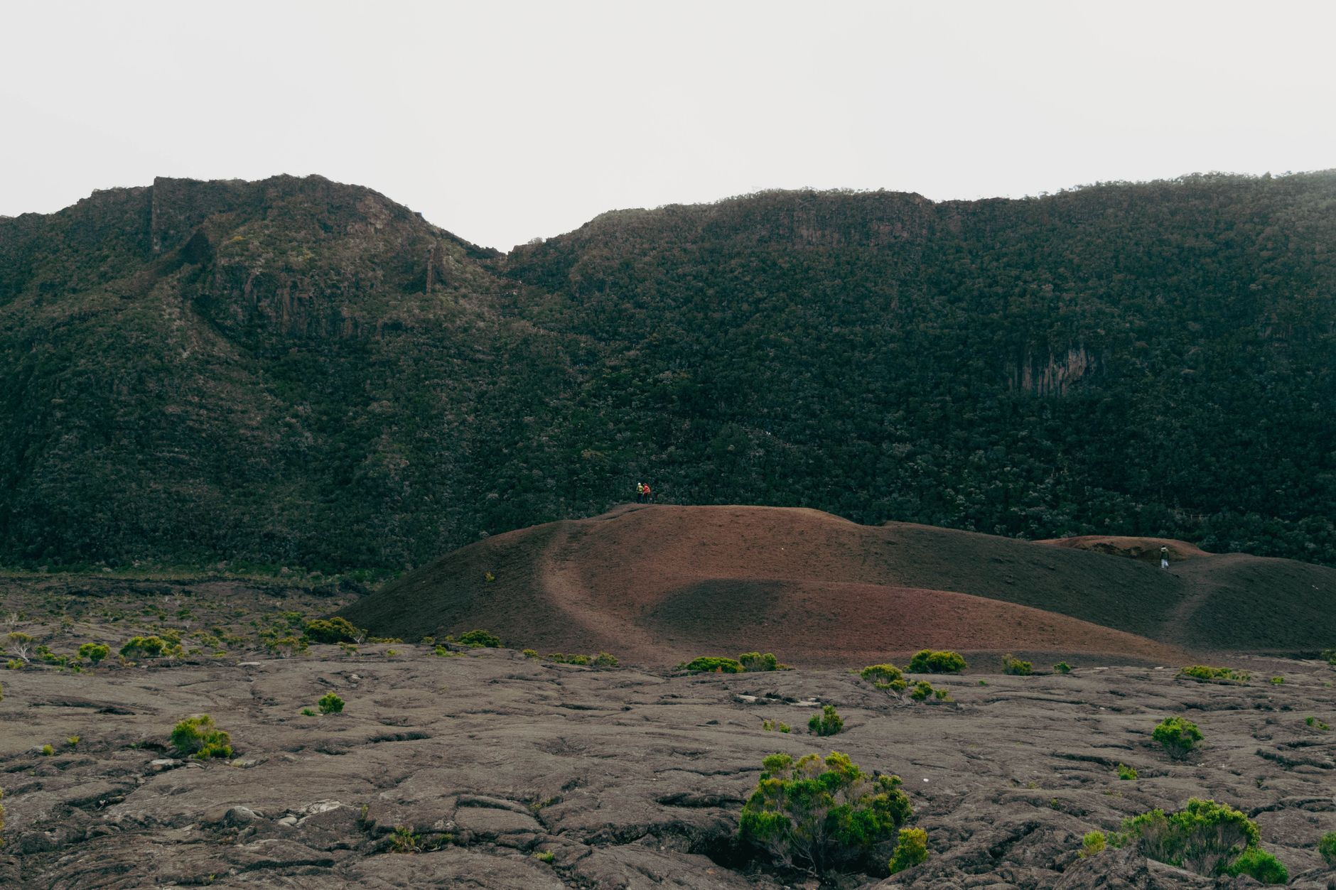 Barren volcanic landscape with steaming vents and cracked earth in an arid depression