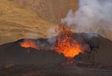 Active lava lake glowing red at night inside a volcanic crater