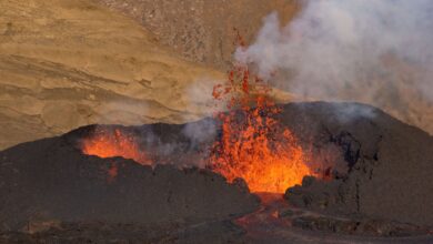 Active lava lake glowing red at night inside a volcanic crater