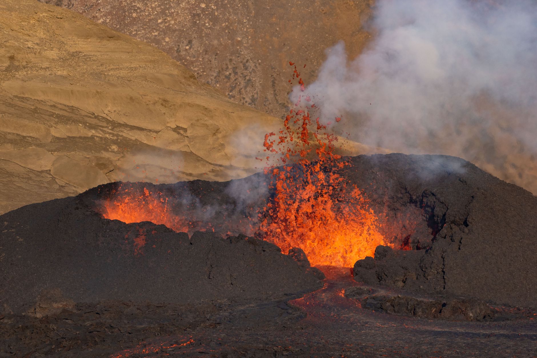 Active lava lake glowing red at night inside a volcanic crater