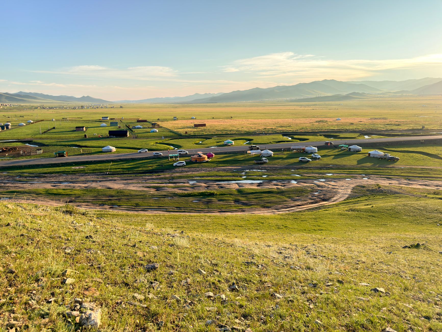 Wide open Mongolian steppe landscape with rolling grassland and clear sky