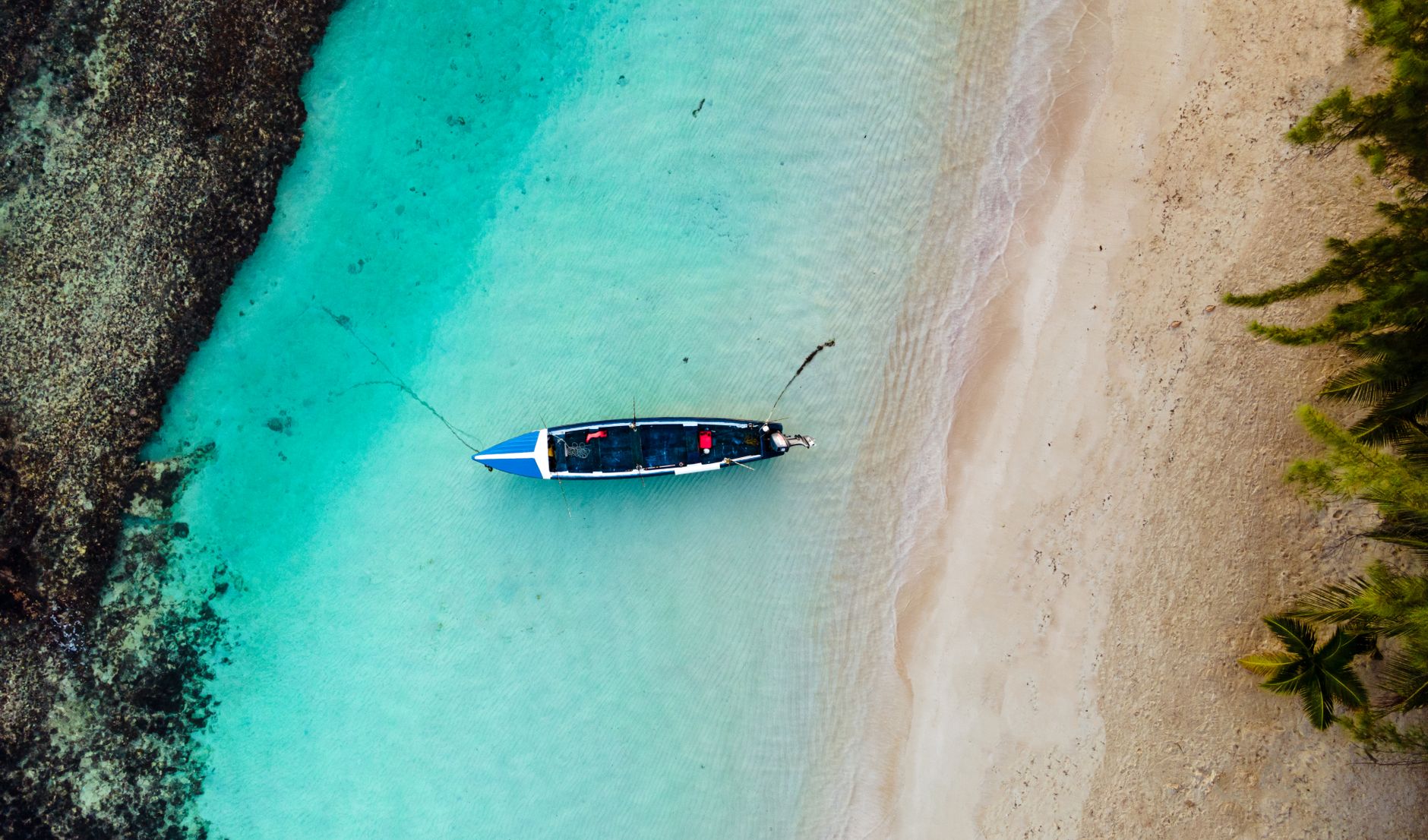 Traditional wooden pirogue boat navigating a narrow river channel at dawn