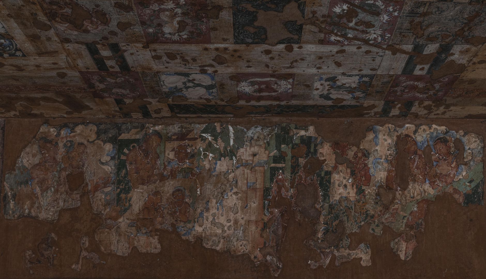 Prehistoric rock art figures painted in ochre on a sandstone wall