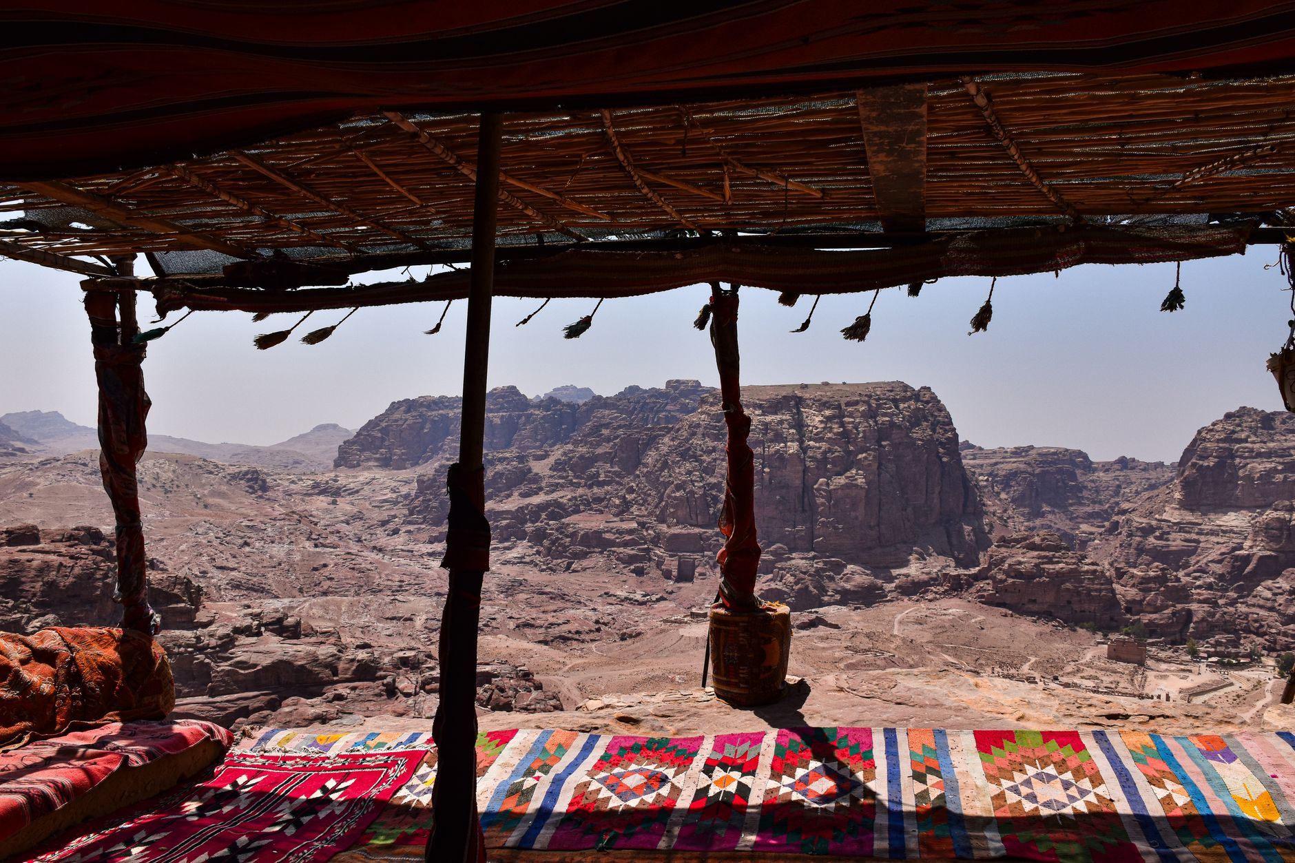 Traditional Bedouin tent camp set against desert rock formations at sunset