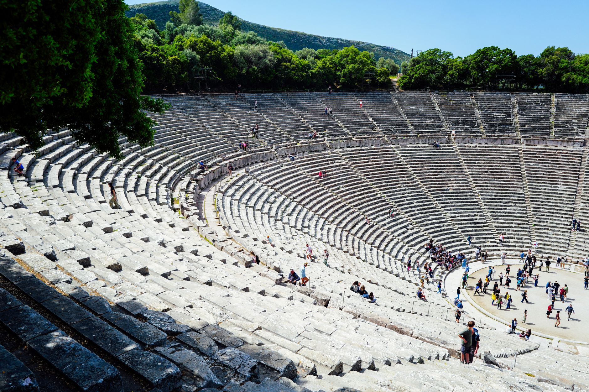 Curved stone seating rows of a well-preserved Roman theater carved into a hillside