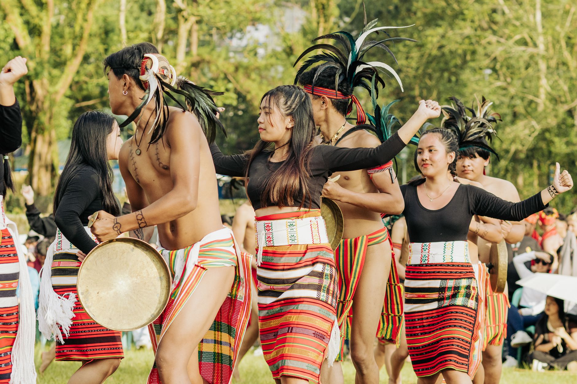 Women in traditional embroidered robes and headdresses dancing in a circle at a cultural festival