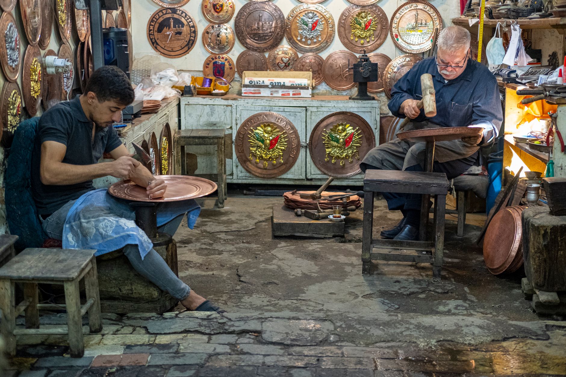 Artisan hammering copper in a traditional metalwork workshop