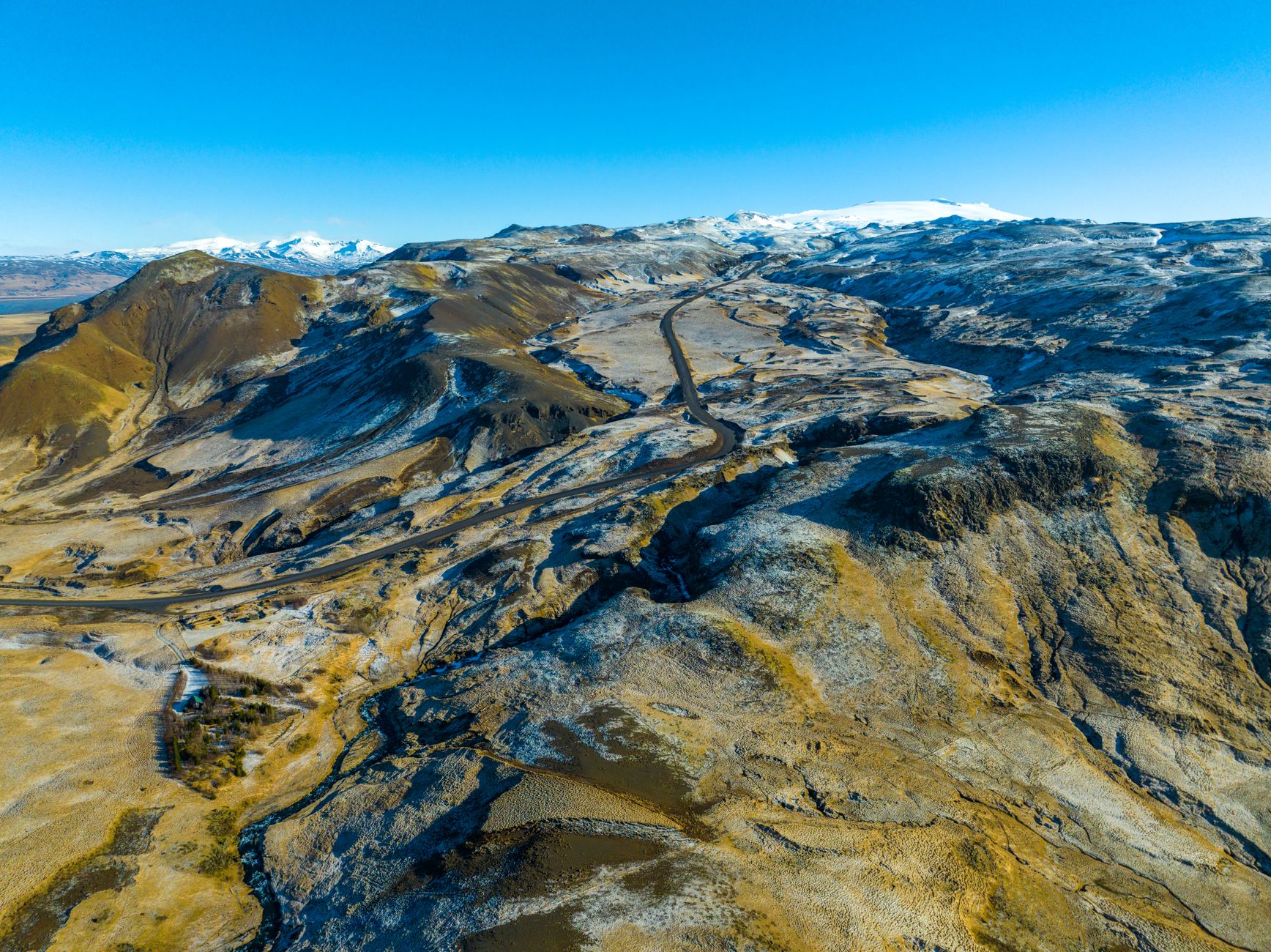 Vast open highland plateau under a wide blue sky with distant mountain ridgeline