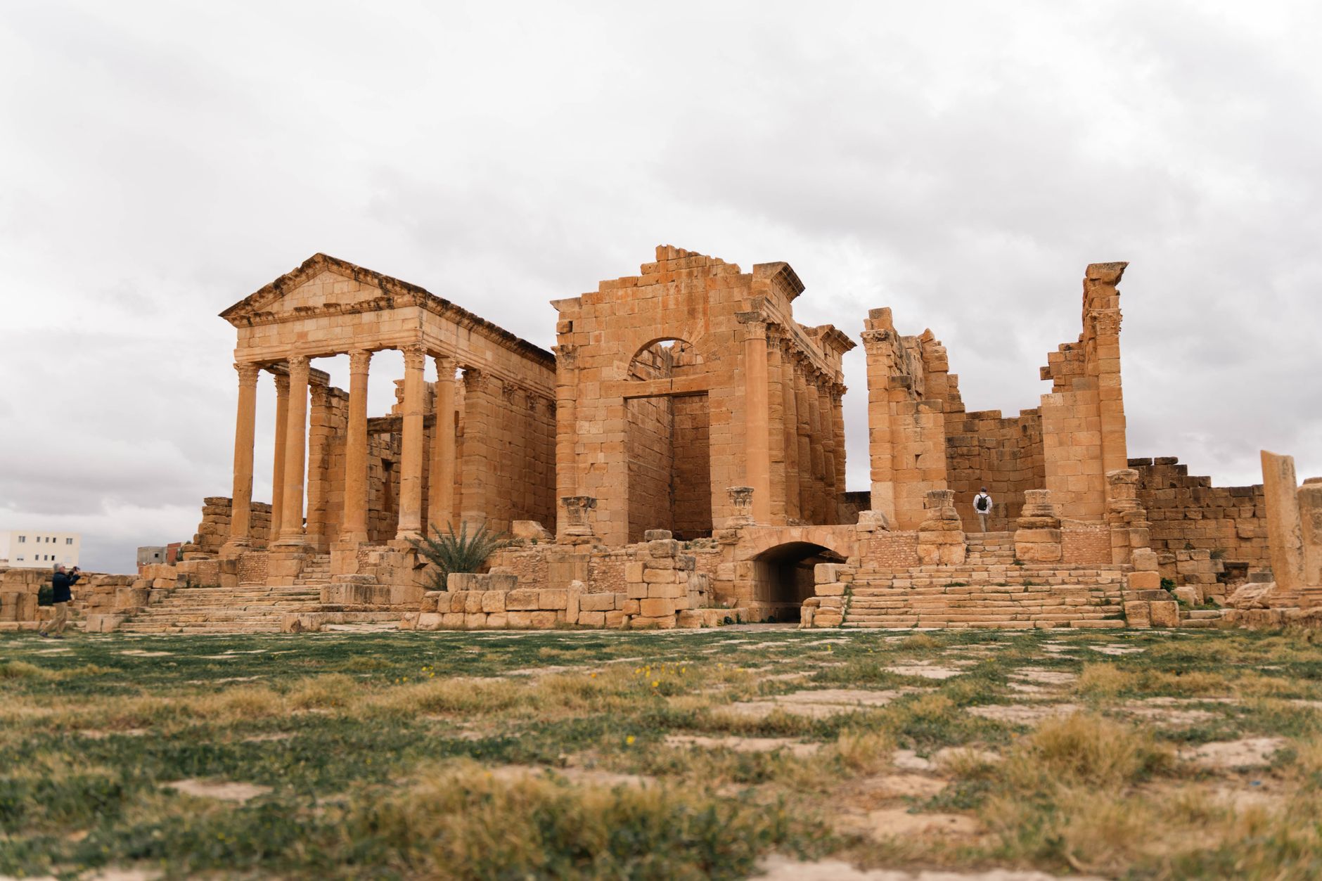 Eroded stone ruins of an ancient structure rising from flat desert landscape