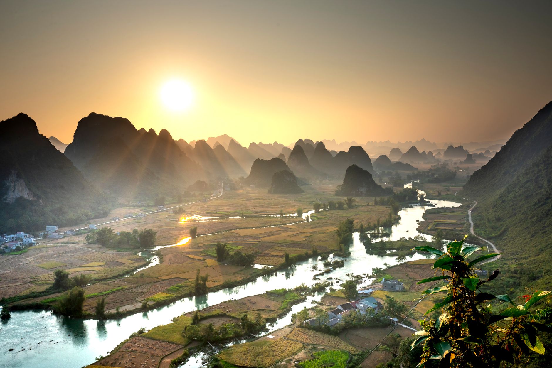 Dramatic limestone karst formations rising above calm water in Southeast Asia