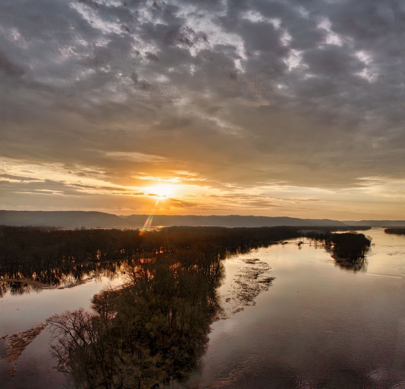 Wide flat floodplain reflecting golden sunrise light across standing water in Zambia