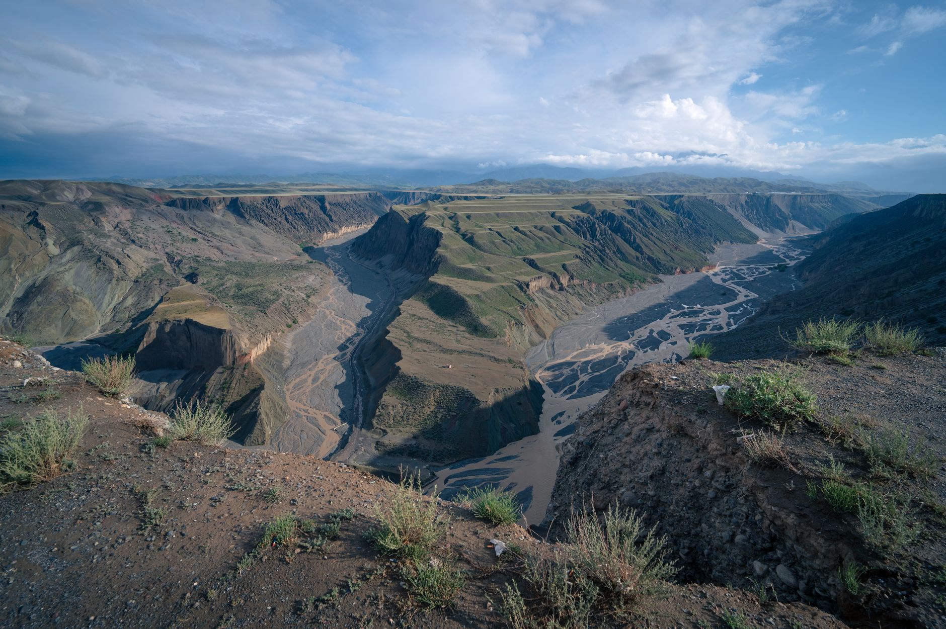 River winding through a high plateau landscape under dramatic evening light